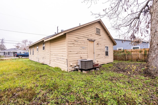 view of outbuilding with central air condition unit and fence