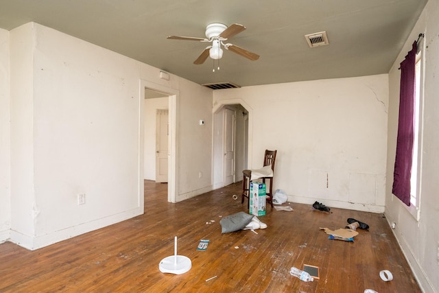 spare room with baseboards, hardwood / wood-style flooring, visible vents, and a ceiling fan