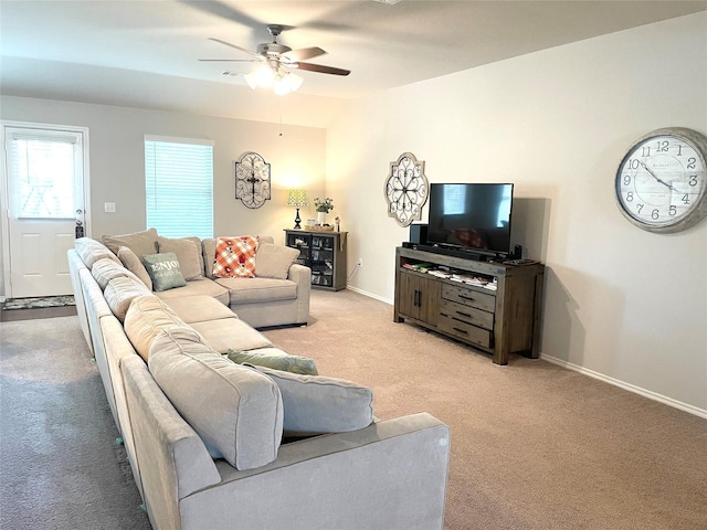 living room with baseboards, ceiling fan, and light colored carpet