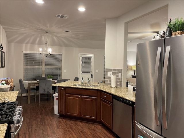 kitchen featuring dark wood-type flooring, a sink, visible vents, appliances with stainless steel finishes, and light stone countertops