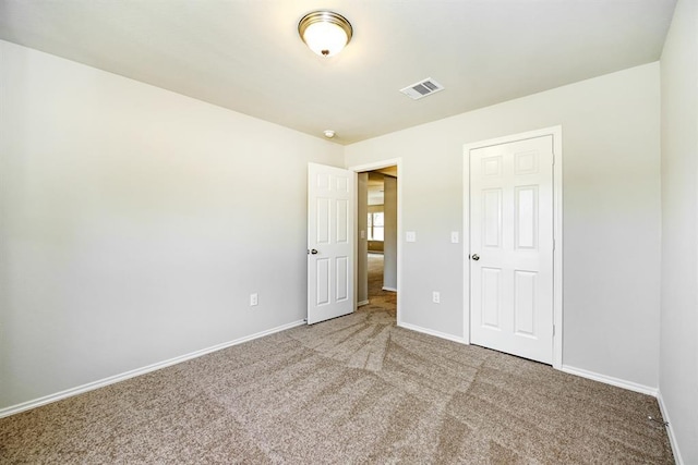 unfurnished bedroom with carpet, visible vents, and baseboards