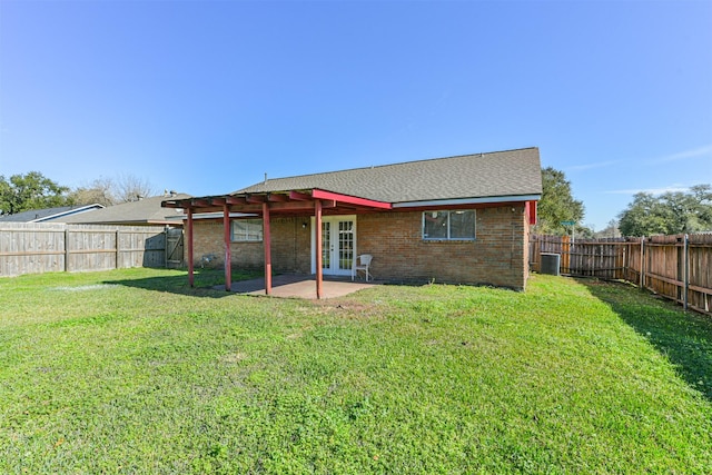 rear view of property with a yard, a patio, french doors, and a fenced backyard