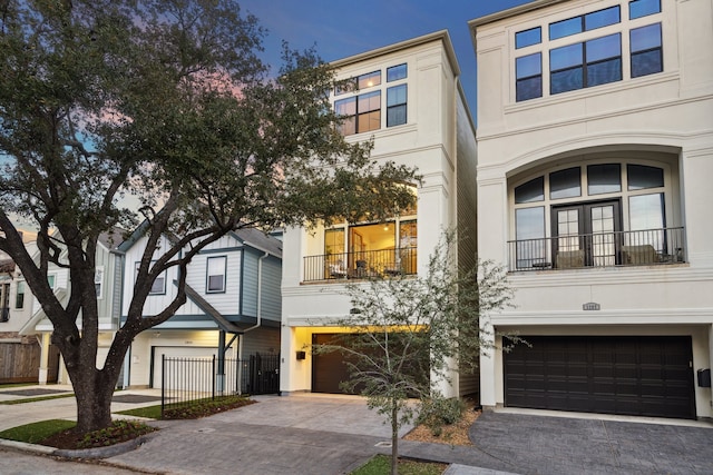 multi unit property with a garage, decorative driveway, and stucco siding