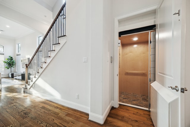 staircase featuring crown molding, arched walkways, wood finished floors, and baseboards