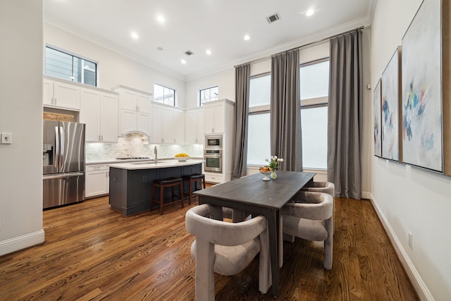 dining area featuring ornamental molding, visible vents, dark wood finished floors, and baseboards