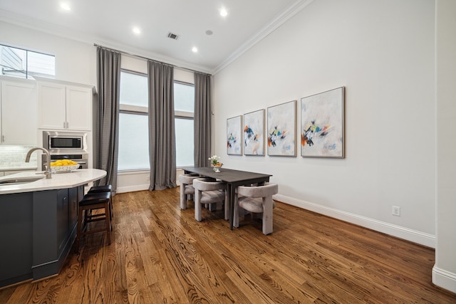 dining room with baseboards, dark wood-type flooring, visible vents, and crown molding