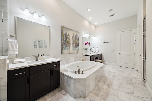 bathroom with marble finish floor, a garden tub, two vanities, visible vents, and a sink