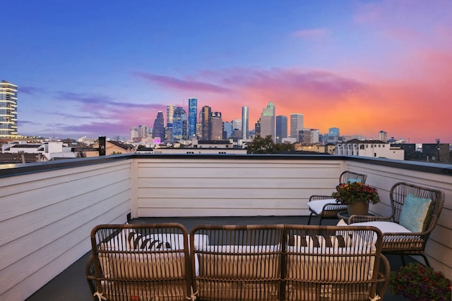 balcony at dusk featuring a city view