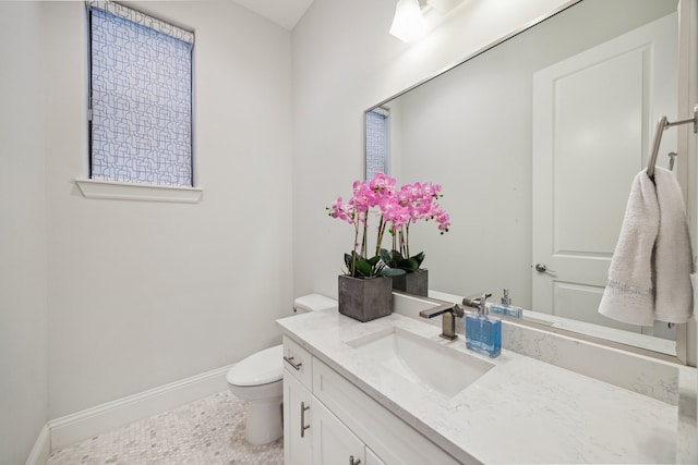 bathroom with toilet, baseboards, and vanity