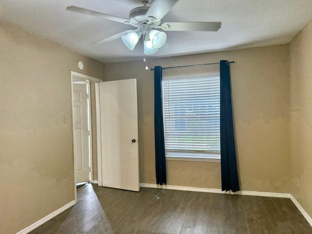 empty room featuring ceiling fan, a textured ceiling, baseboards, and wood finished floors