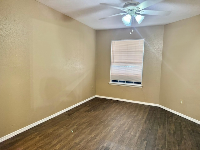 empty room featuring wood finished floors, a ceiling fan, and baseboards