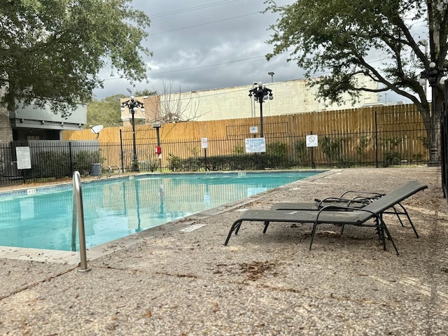 pool featuring fence and a patio