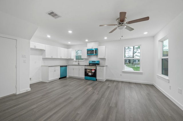 kitchen featuring appliances with stainless steel finishes, white cabinets, visible vents, and a healthy amount of sunlight