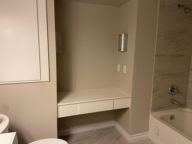 full bath with washtub / shower combination, marble finish floor, toilet, and baseboards