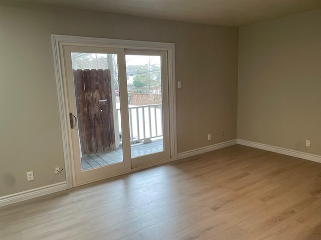 doorway to outside featuring light wood-style flooring and baseboards