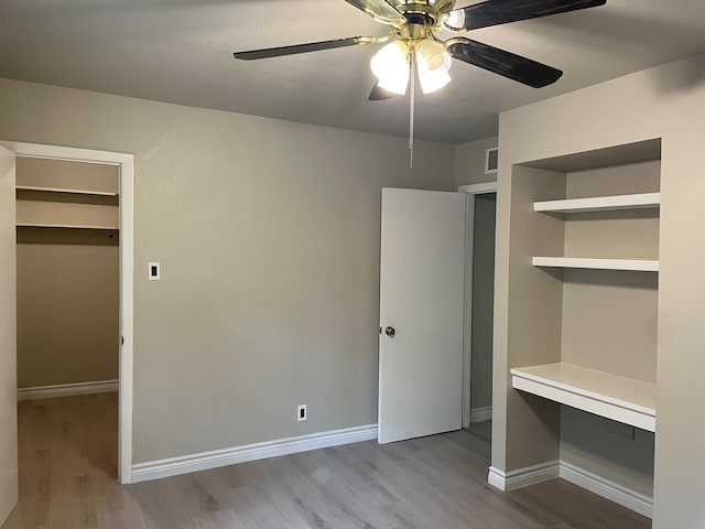 unfurnished bedroom with visible vents, baseboards, and wood finished floors