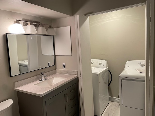 laundry room featuring a sink, laundry area, marble finish floor, and washer and dryer