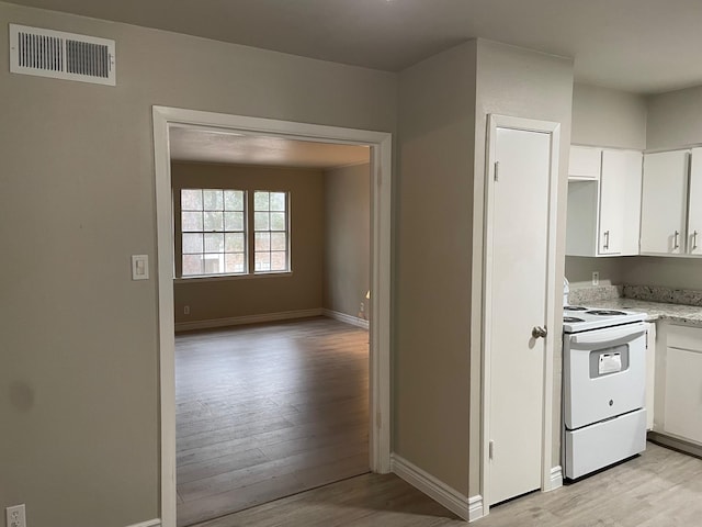 kitchen featuring white cabinetry, visible vents, light wood finished floors, and white electric range oven