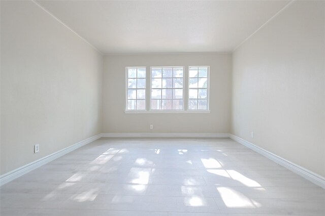 spare room with baseboards, crown molding, and light tile patterned flooring