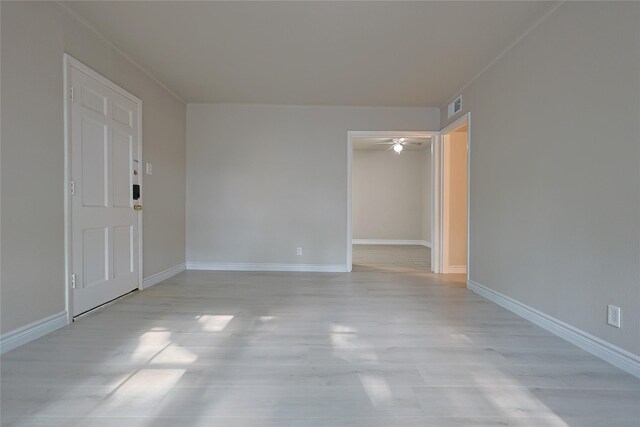 spare room with light wood-type flooring, baseboards, and visible vents