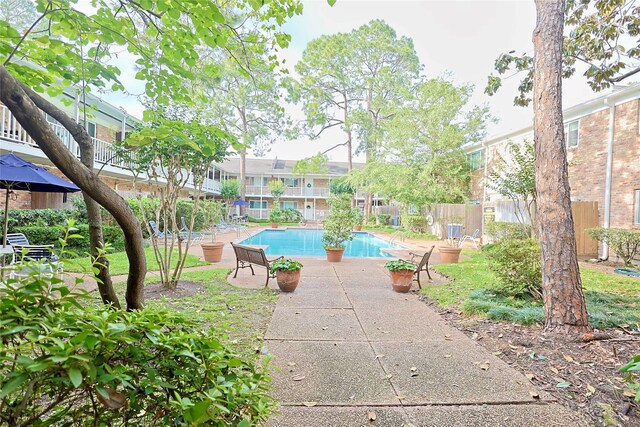 pool with fence and a patio area