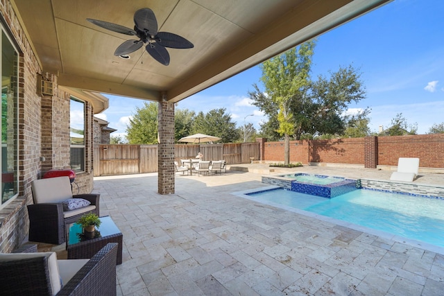 view of pool featuring a patio, a fenced backyard, an outdoor living space, a pool with connected hot tub, and a ceiling fan