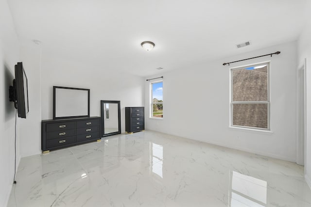 unfurnished bedroom with marble finish floor, baseboards, and visible vents