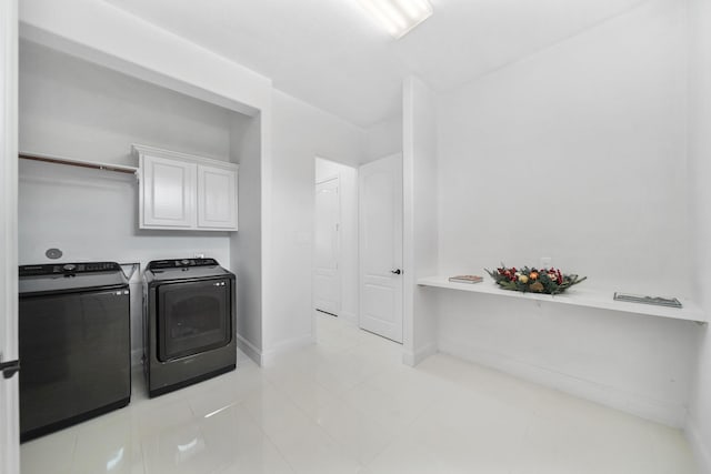 laundry area featuring cabinet space, baseboards, and washer and dryer