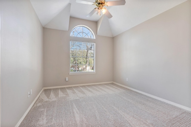 carpeted spare room with lofted ceiling, ceiling fan, and baseboards