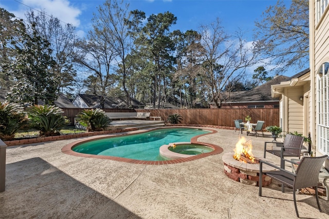 view of swimming pool featuring an outdoor fire pit, a patio area, a fenced backyard, and a pool with connected hot tub