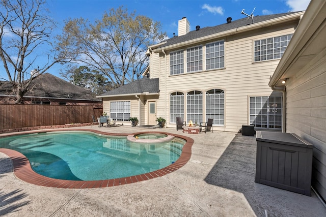 view of pool featuring a patio area, a pool with connected hot tub, and fence