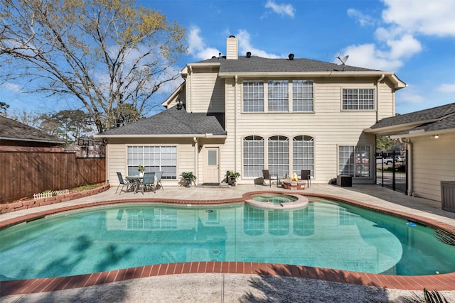 view of pool featuring a pool with connected hot tub, a patio, and fence