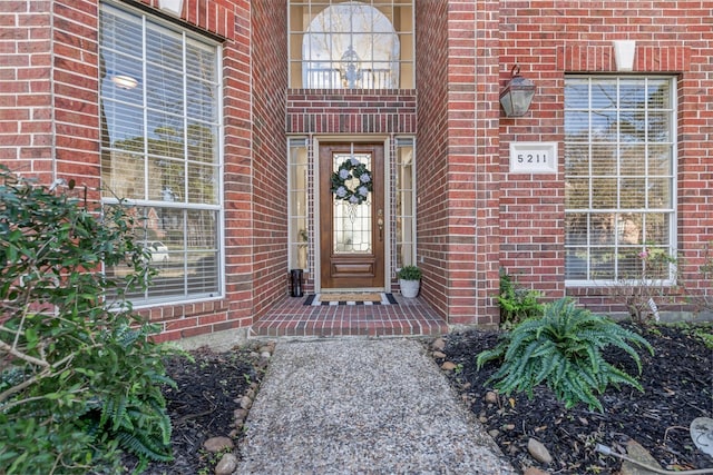 doorway to property with brick siding