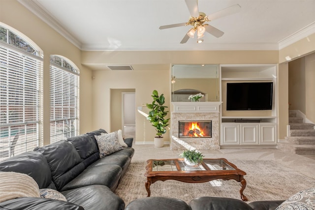 carpeted living room with ornamental molding, stairway, a glass covered fireplace, and visible vents