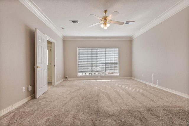 spare room with light carpet, baseboards, visible vents, and crown molding