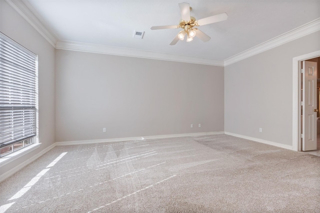 carpeted spare room featuring ornamental molding, visible vents, ceiling fan, and baseboards