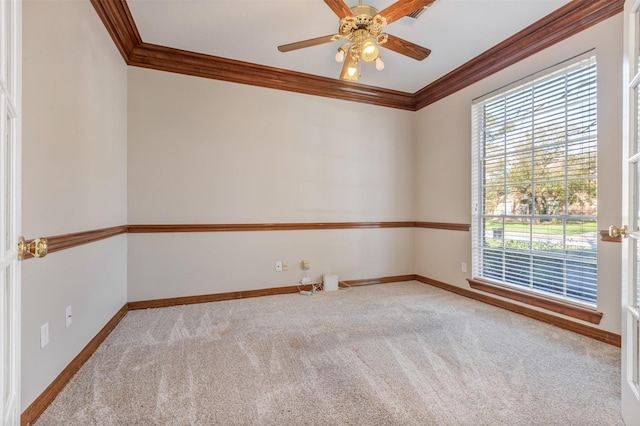 unfurnished room featuring carpet floors, crown molding, visible vents, ceiling fan, and baseboards