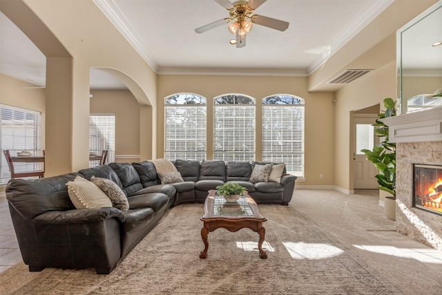 living room featuring ornamental molding, a tile fireplace, and visible vents