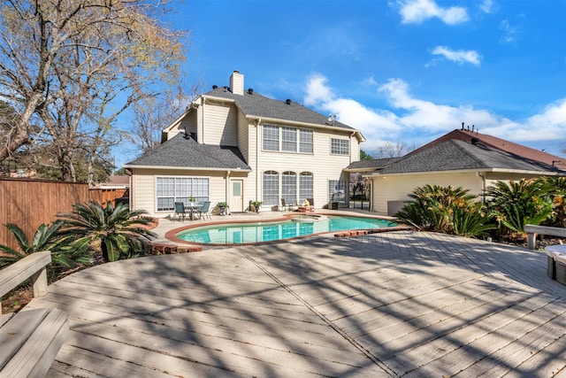 back of property featuring a fenced in pool, a chimney, a patio area, fence, and a wooden deck