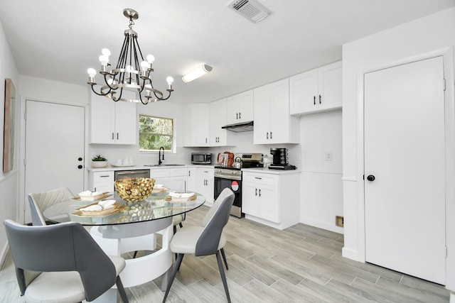 dining space with wood finish floors, visible vents, and a notable chandelier