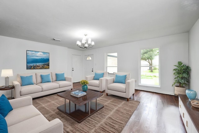 living area featuring visible vents, a notable chandelier, and wood finished floors