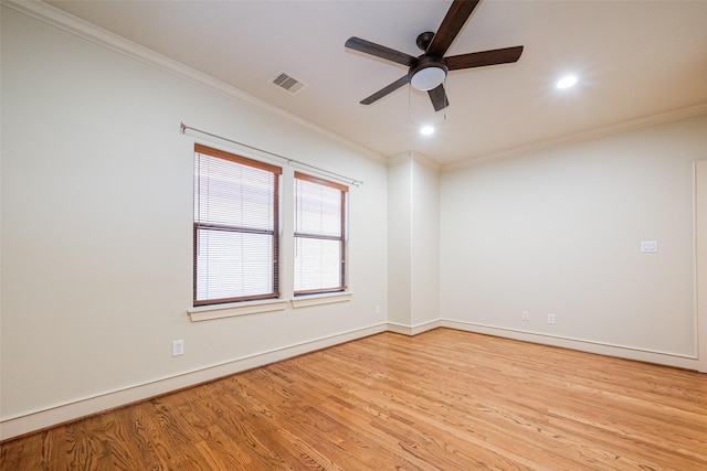 unfurnished room featuring visible vents, crown molding, baseboards, wood finished floors, and a ceiling fan