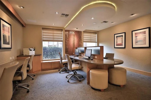 carpeted office space featuring visible vents and a textured wall