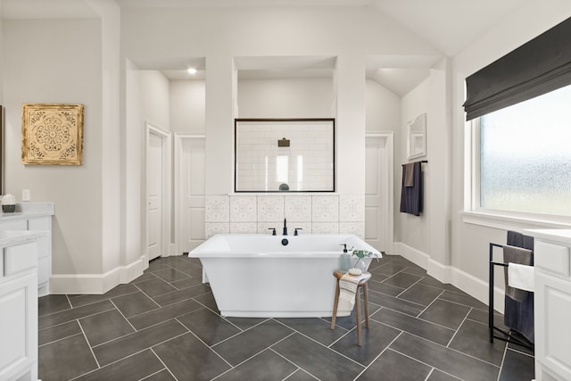 bathroom featuring tile patterned flooring, tile walls, vaulted ceiling, a soaking tub, and a tile shower