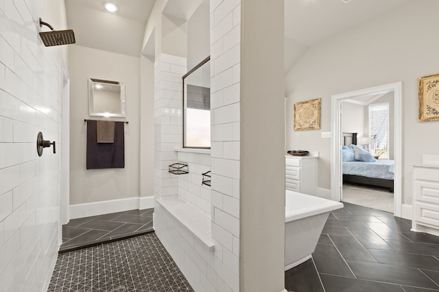 ensuite bathroom featuring tile patterned flooring, connected bathroom, a freestanding bath, and tiled shower