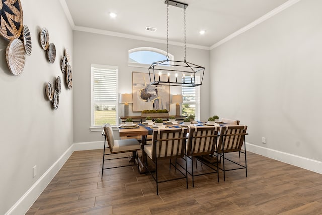 dining area with a healthy amount of sunlight, crown molding, and wood finished floors