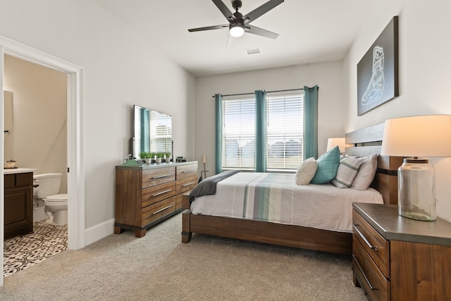 bedroom featuring visible vents, a ceiling fan, light carpet, connected bathroom, and baseboards