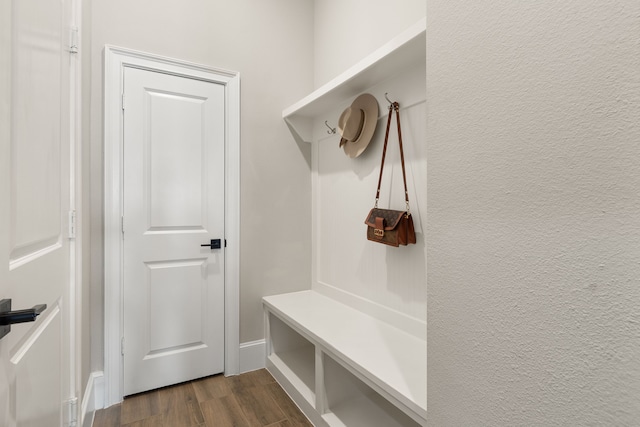 mudroom featuring dark wood-type flooring and a textured wall