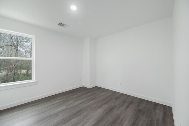 unfurnished room featuring recessed lighting, visible vents, dark wood finished floors, and baseboards