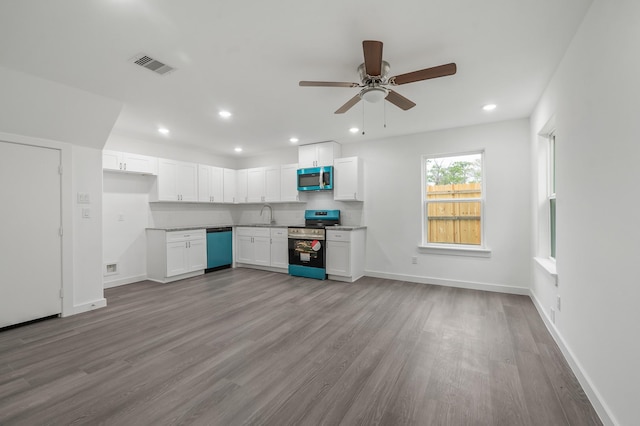 kitchen featuring appliances with stainless steel finishes, white cabinets, visible vents, and wood finished floors